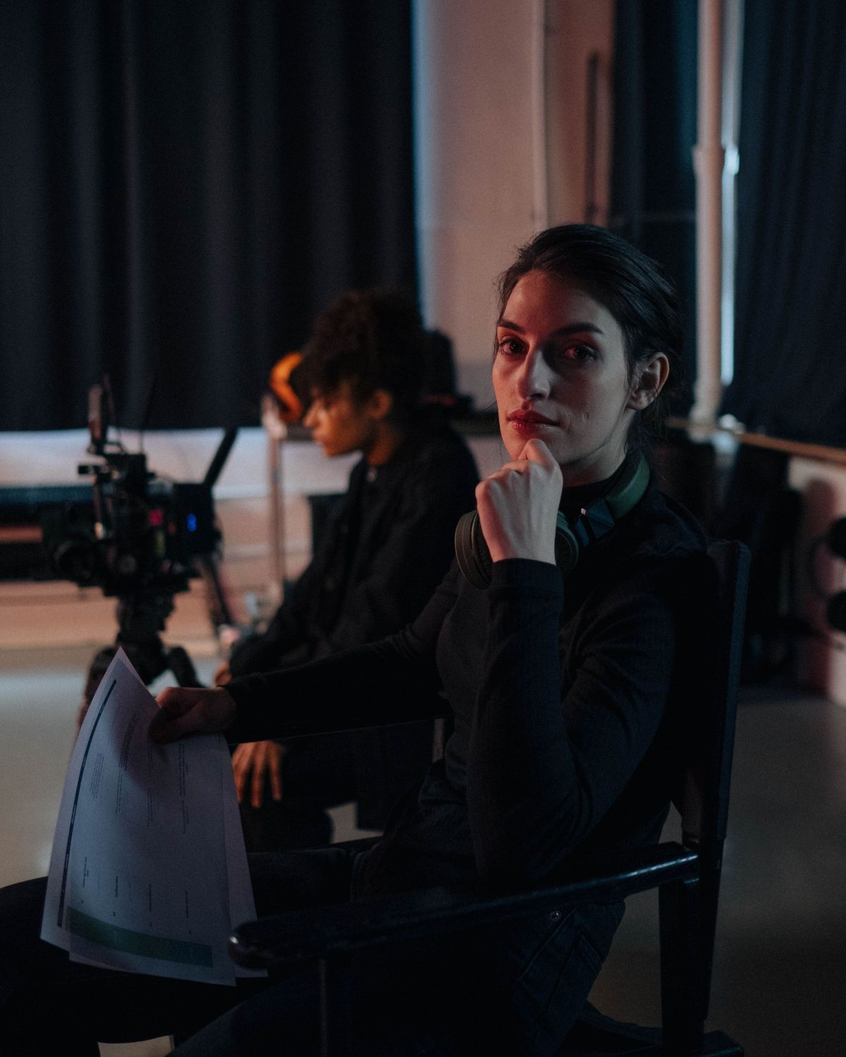 A producer in a director’s chair with a script in her lap