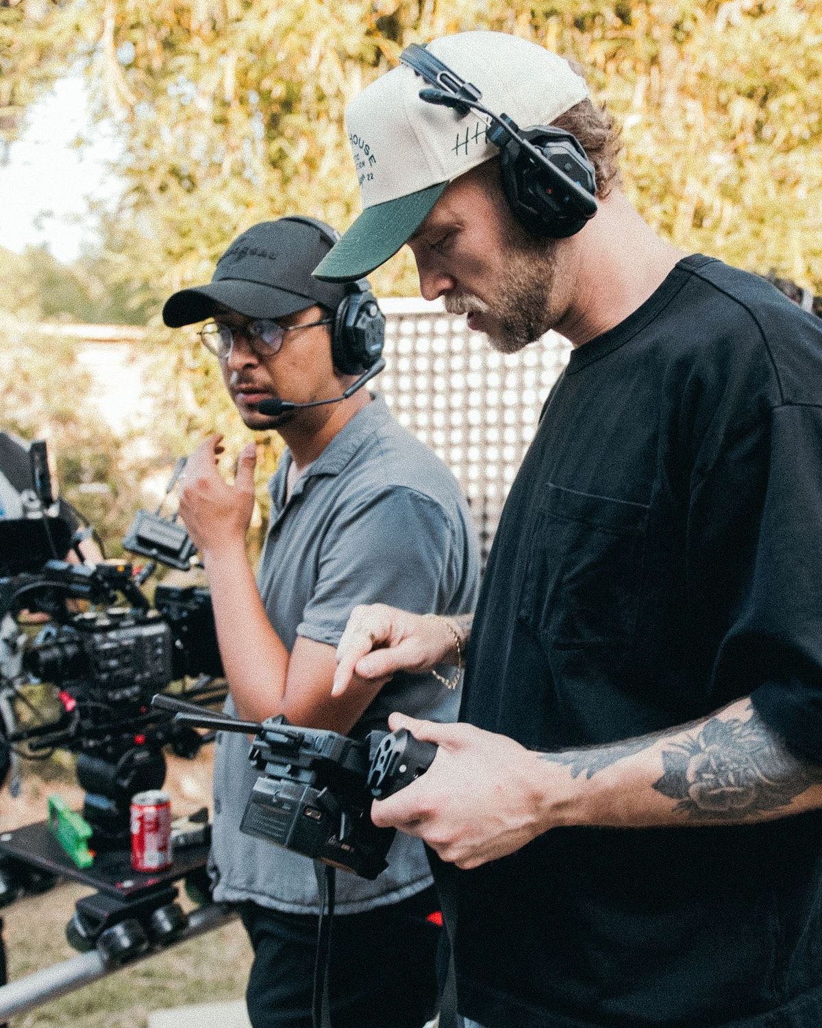 Two crew members over a camera rig on an outdoor set